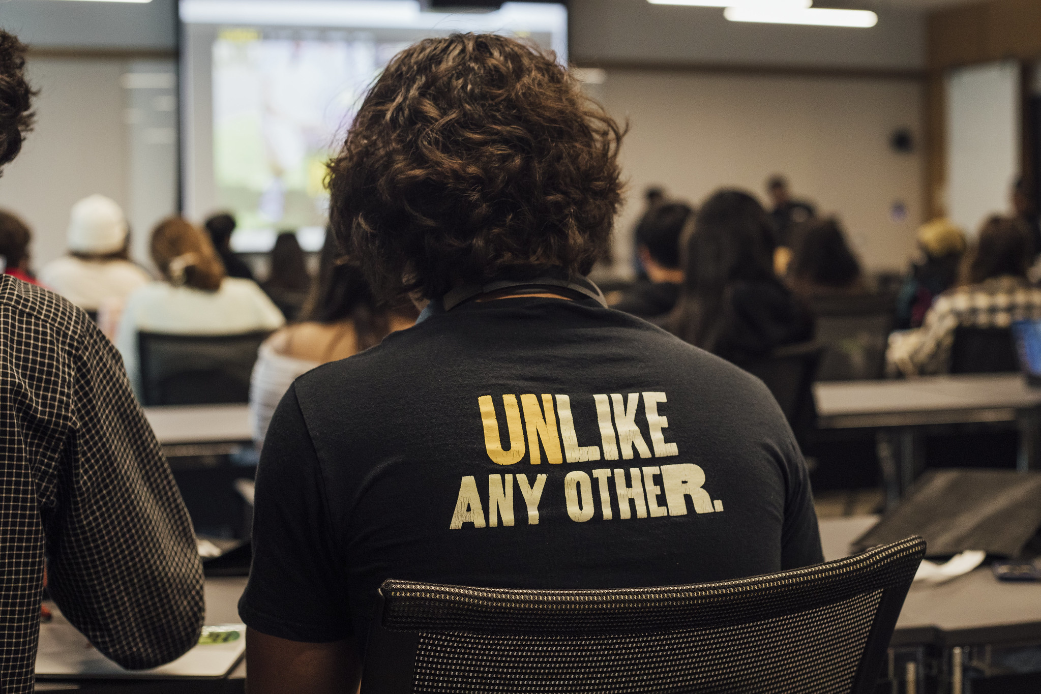 Back of a students t-shirt that says unlike any other