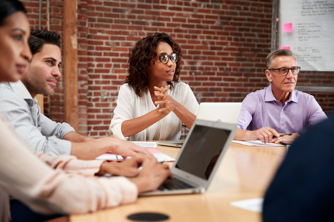 A group of people sitting around a conference table having a meeting